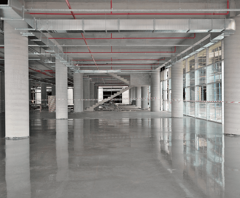 Empty industrial warehouse with polished concrete floor.